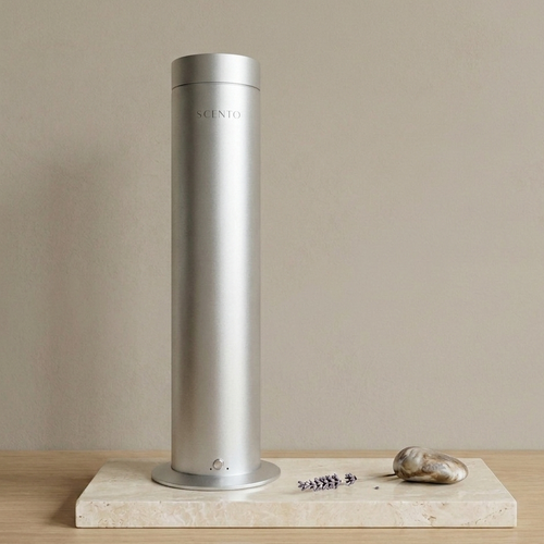 Silver home diffuser on a beige surface with a neutral background